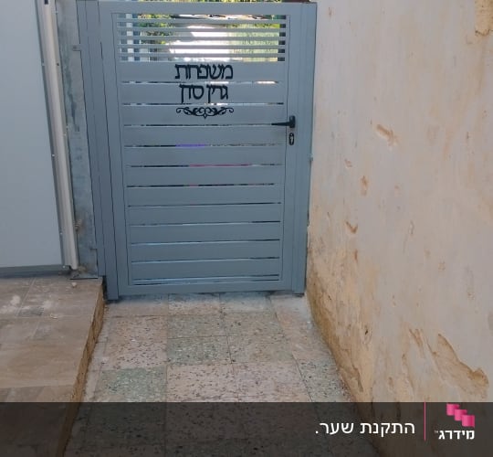 שער מתכת אפור עם כיתוב משפחת גזסן